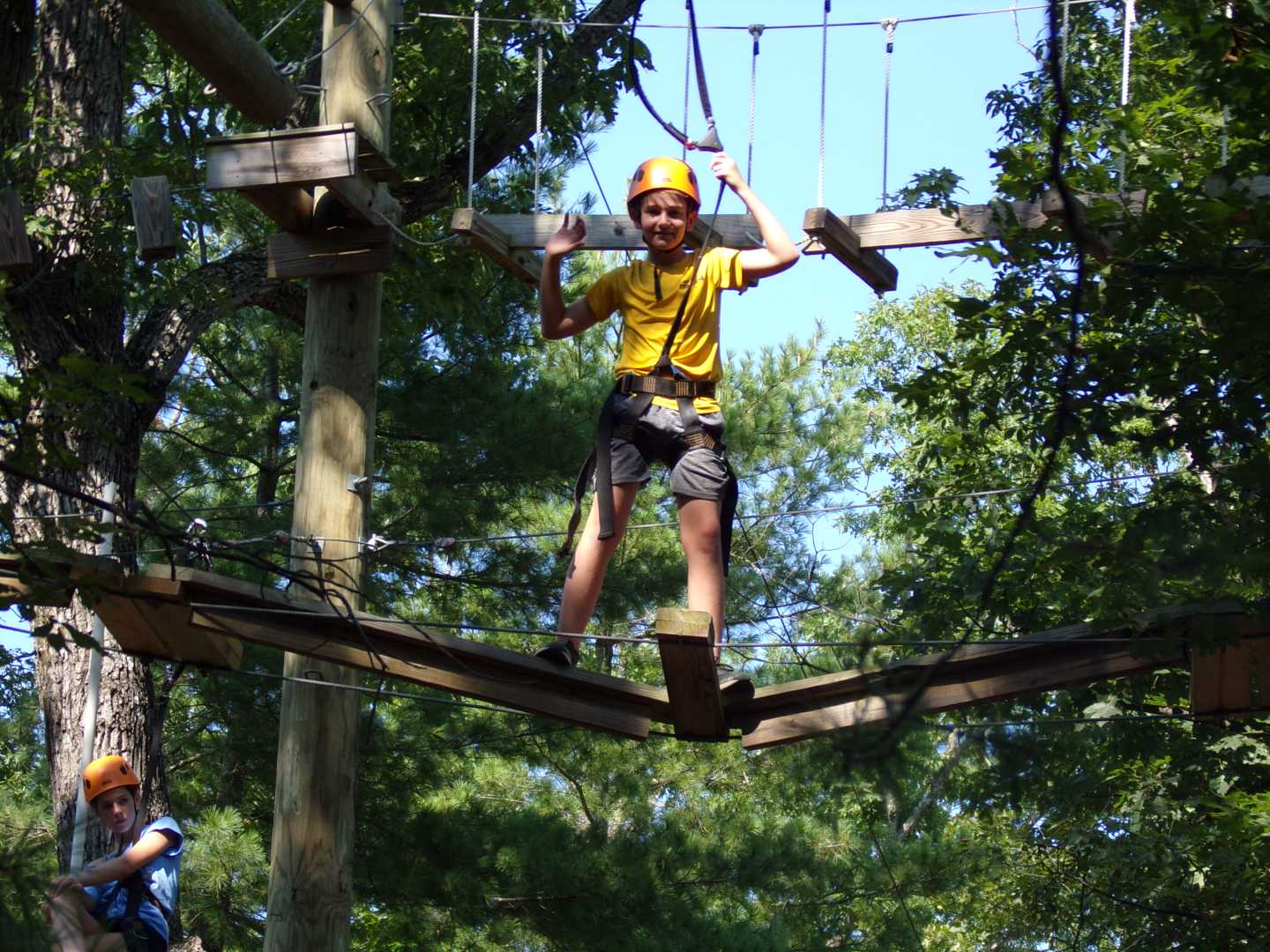 2025 Camp Tall Timbers overnight camp member climbing across a rope bridge