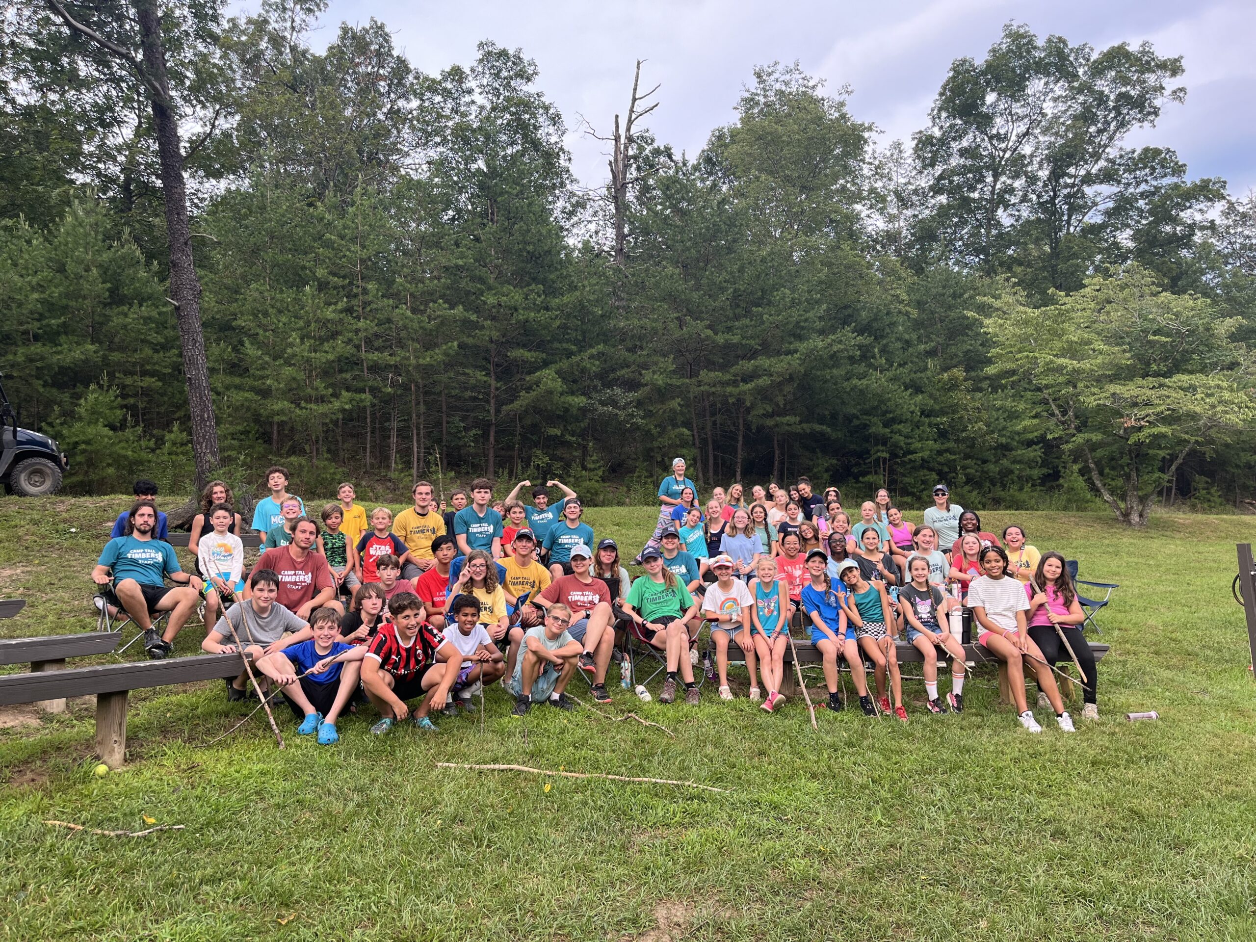 Summer camp members at Camp Tall Timbers sitting on benches