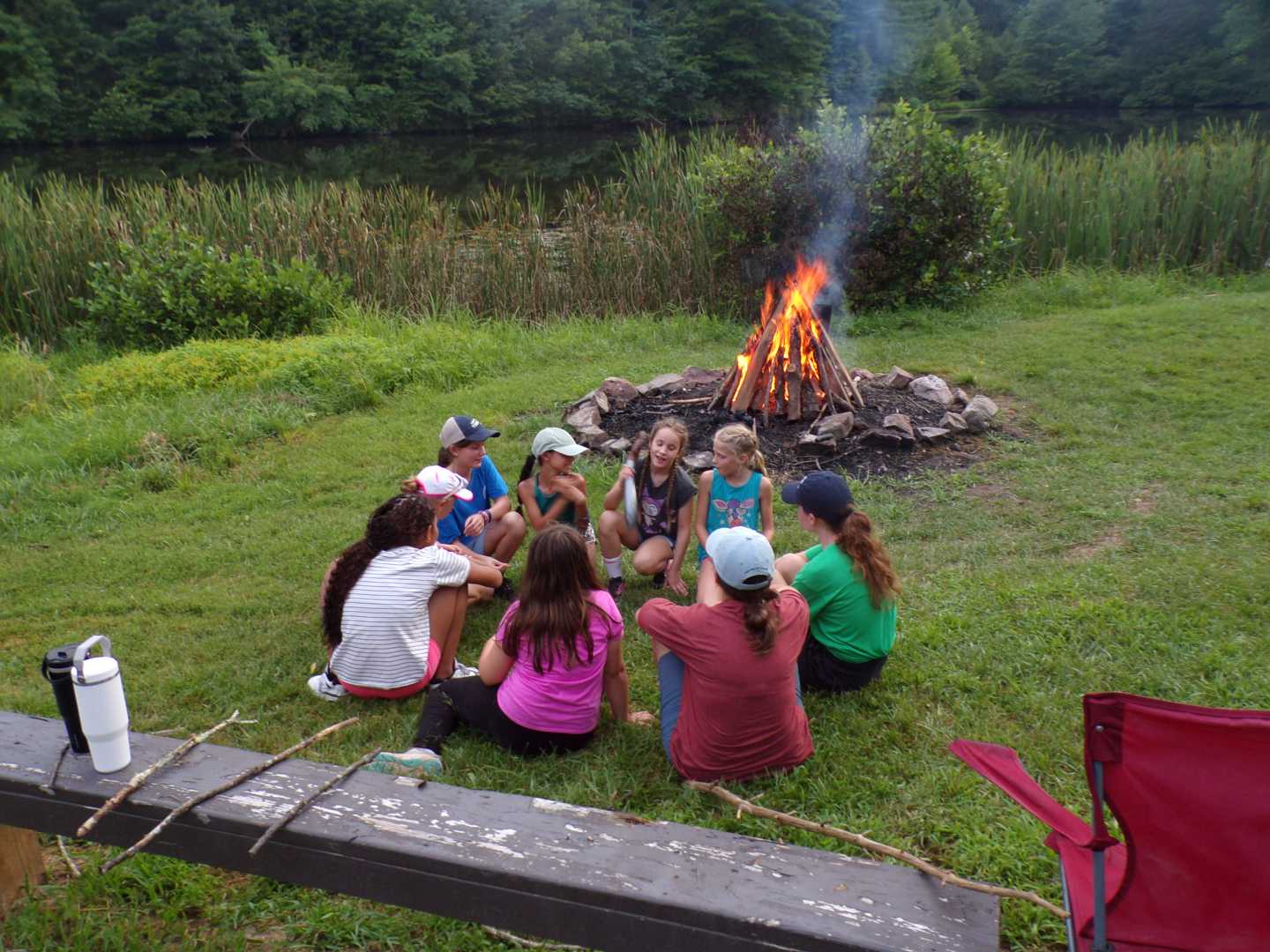 A group of girls sitting together at a bonfire