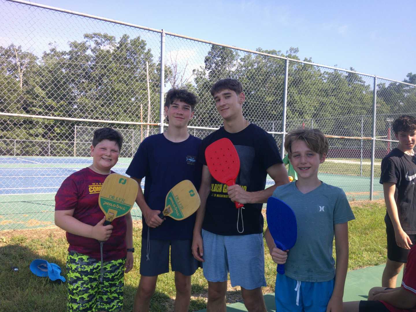 Four Camp Tall Timbers campers holding pickleball rackets